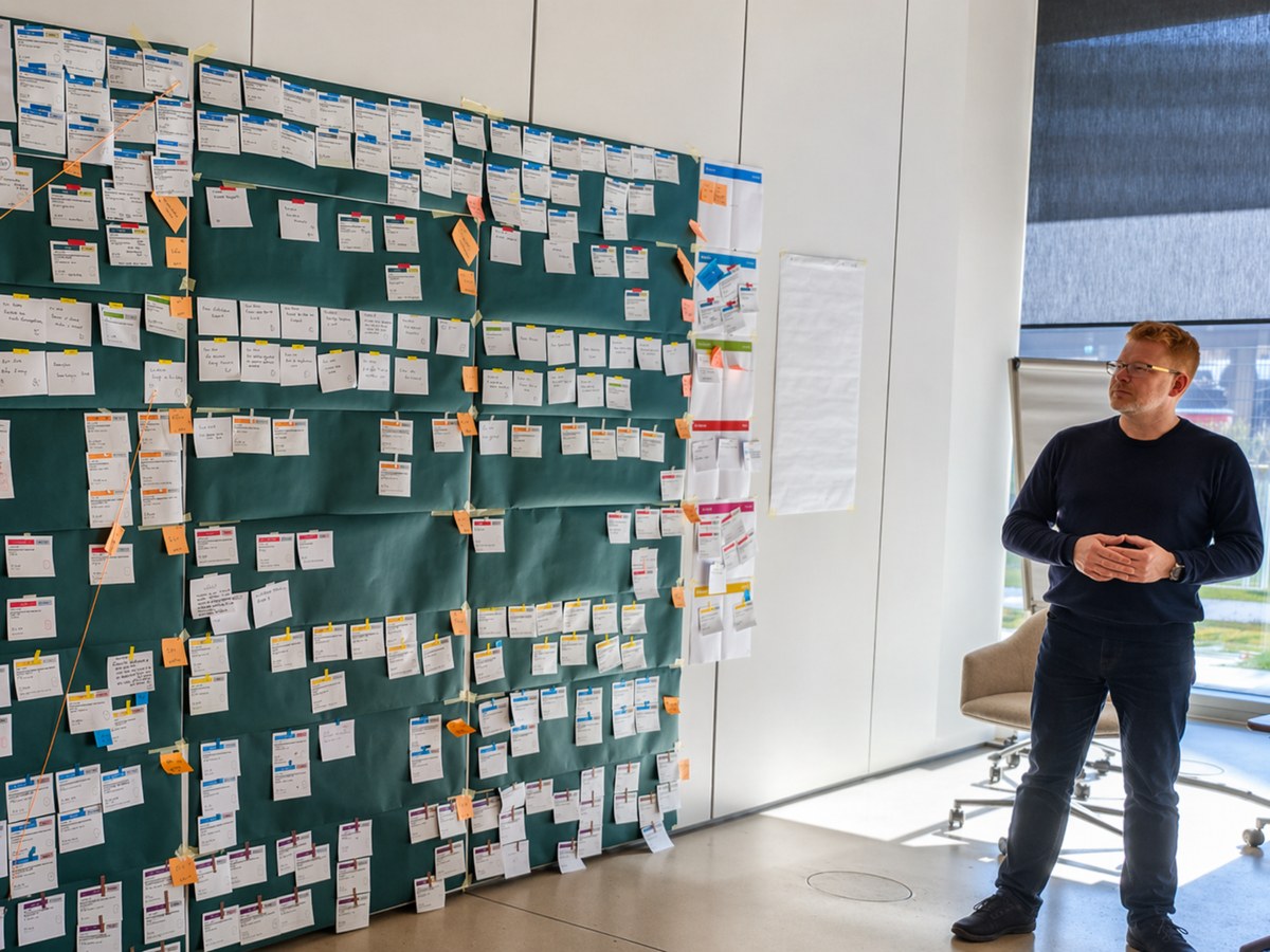 Arnd Bochmann neben einem großen Kanban-Board in einem Workshop